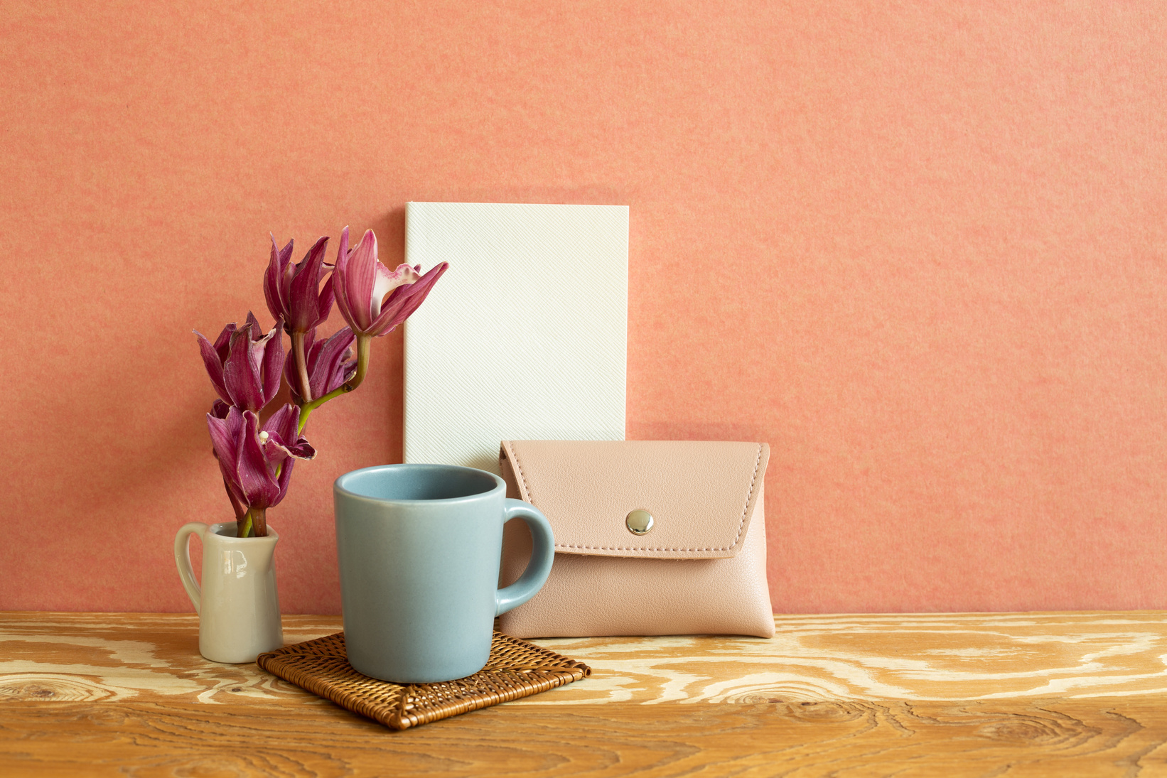Mug, Flower, and Wallet on Wooden Desk